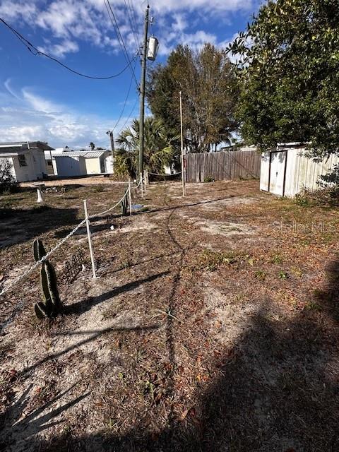 Back yard with metal storage shed in back of mobile home.