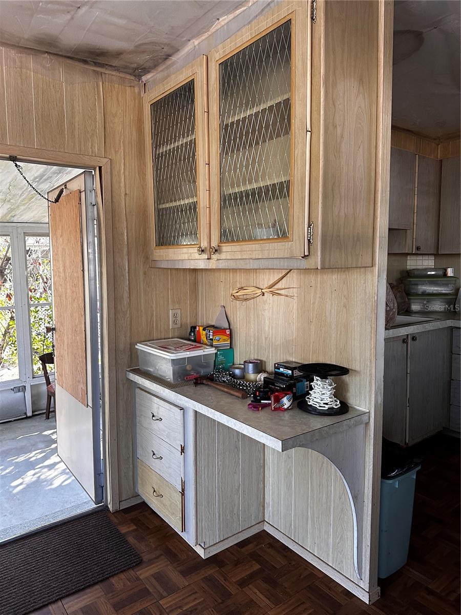 Desk area and cabinet by front door.  Kitchen to the right.