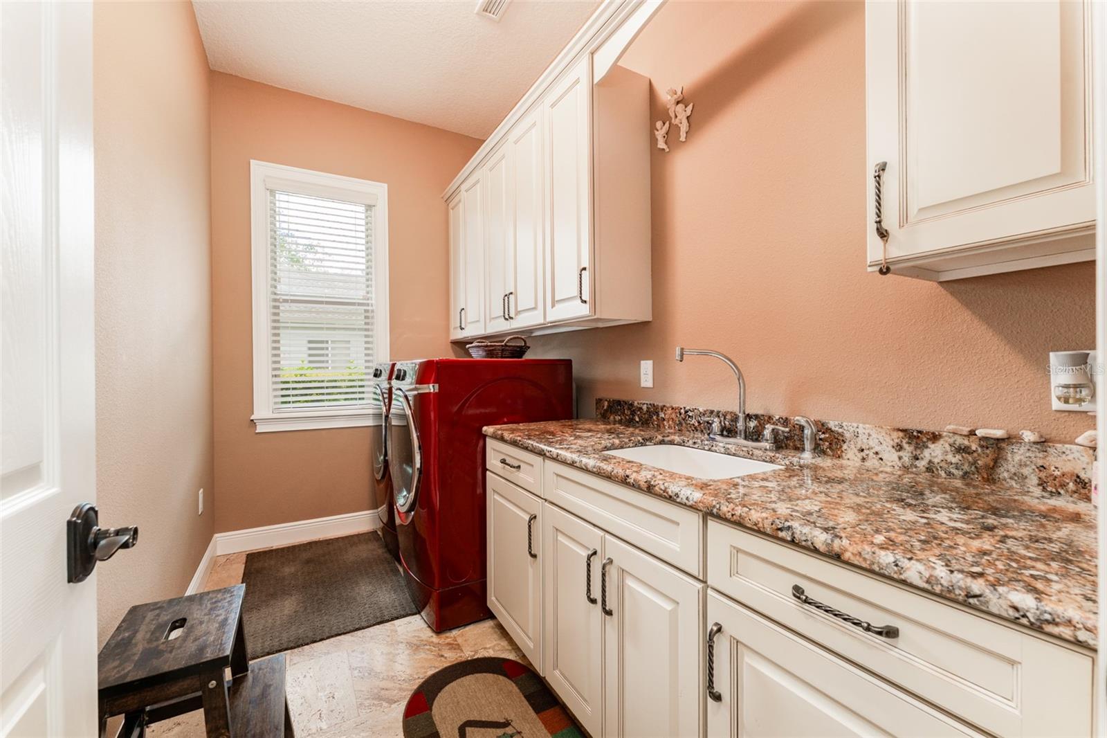 Laundry Room with Washer & Dryer That Convey, Built in Cabinets, Utility Sink & Window Providing Natural Lighting