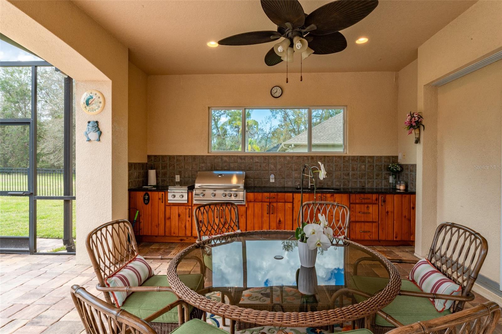 Covered Outdoor Kitchen with Granite Tops & Lovely Wood Cabinetry