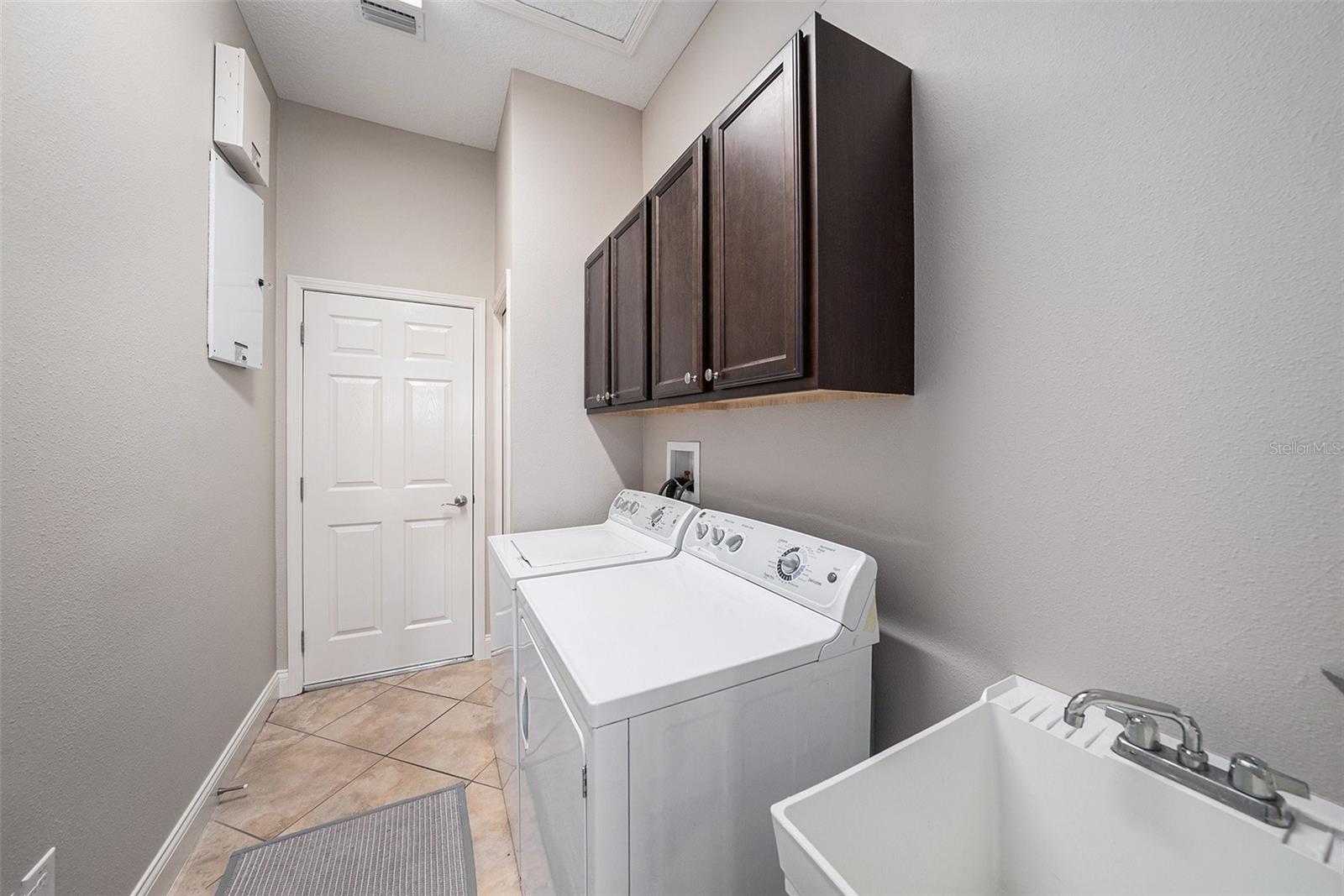 Designated laundry room with storage and utility sink