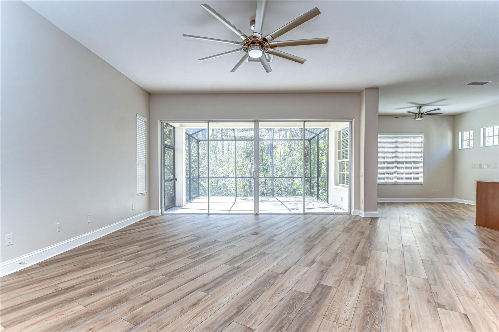 Bask in the natural light streaming through expansive windows and sliding doors in this open living space.