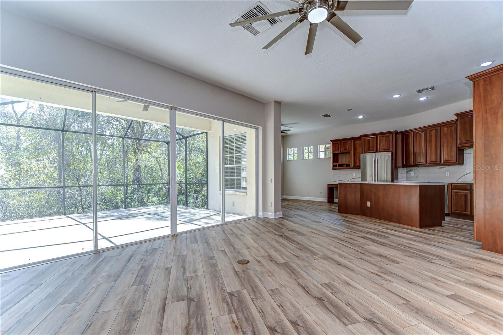 The sleek kitchen and expansive screened lanai offer a seamless blend of indoor and outdoor living