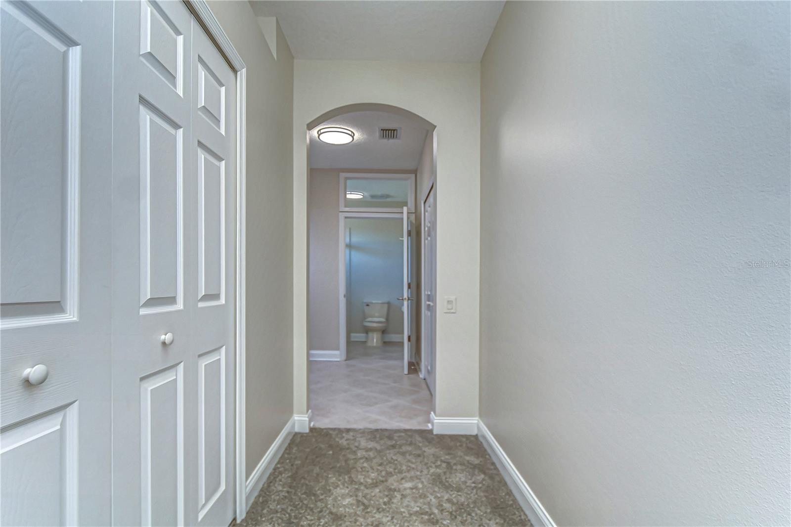 Step into a warm welcome with this inviting hallway, leading to a bright and spacious bathroom.