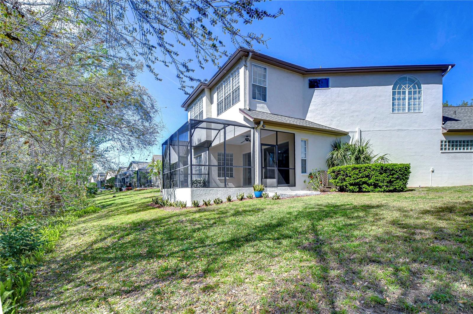 Nestled against lush greenery, it offers serene views and a peaceful backyard retreat.