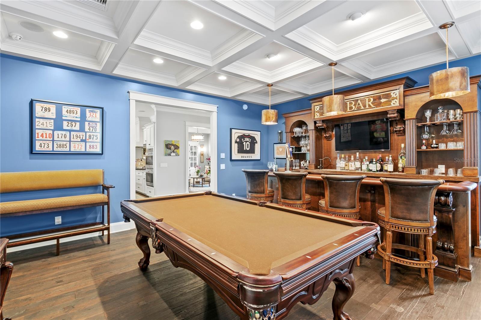 A custom bar/game room with 2 tap-keg system, wine cooler, LED lighting, Scotsman nugget cube icemaker, adjacent to the Great Room and Kitchen.