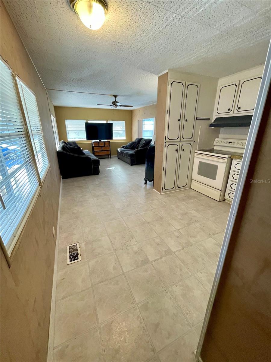 Looking into the kitchen and living area, very open, vinyl flooring