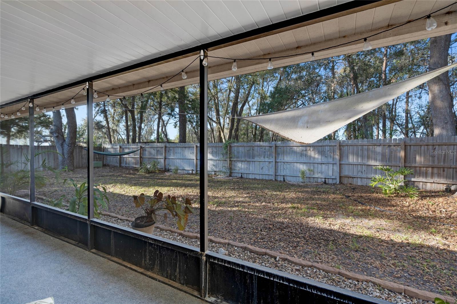 View of fully fenced backyard from patio; tons of shade & no rear neighbors.