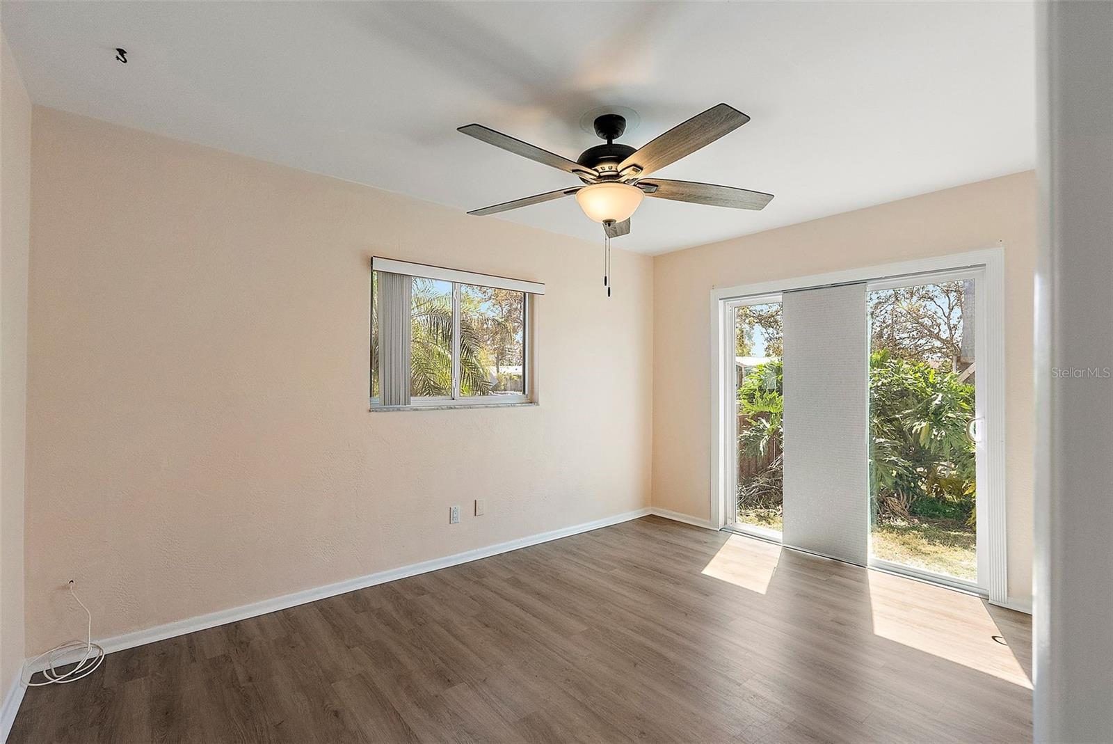 MASTER BEDROOM WITH WINDOW FACING FRONT YARD AND SLIDING DOOR INTO PRIVATE FENCED SIDE YARD