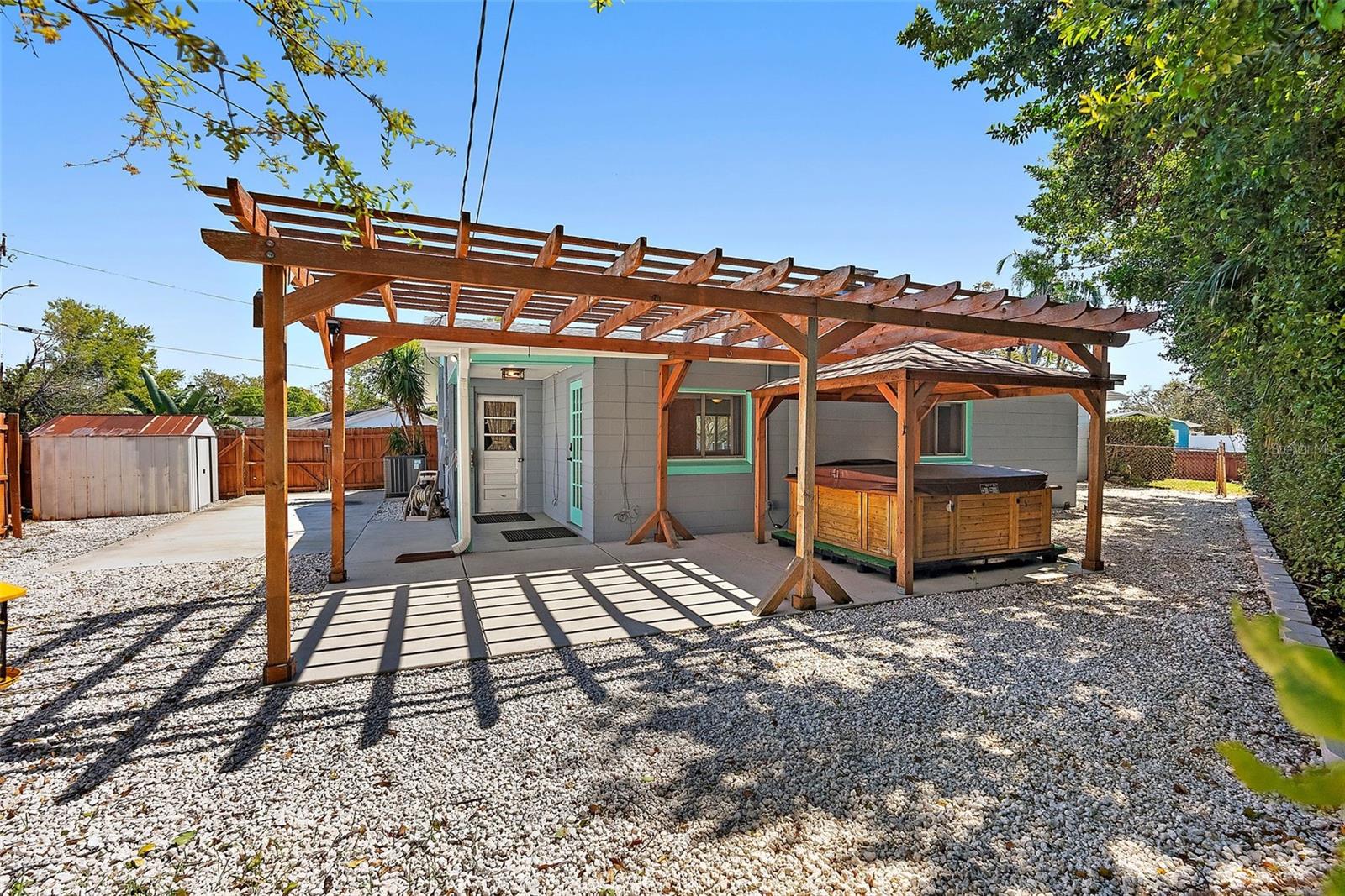 NEWLY PEBBLED BACK YARD WITH HOT TUB UNDER IT'S OWN GAZEBO.