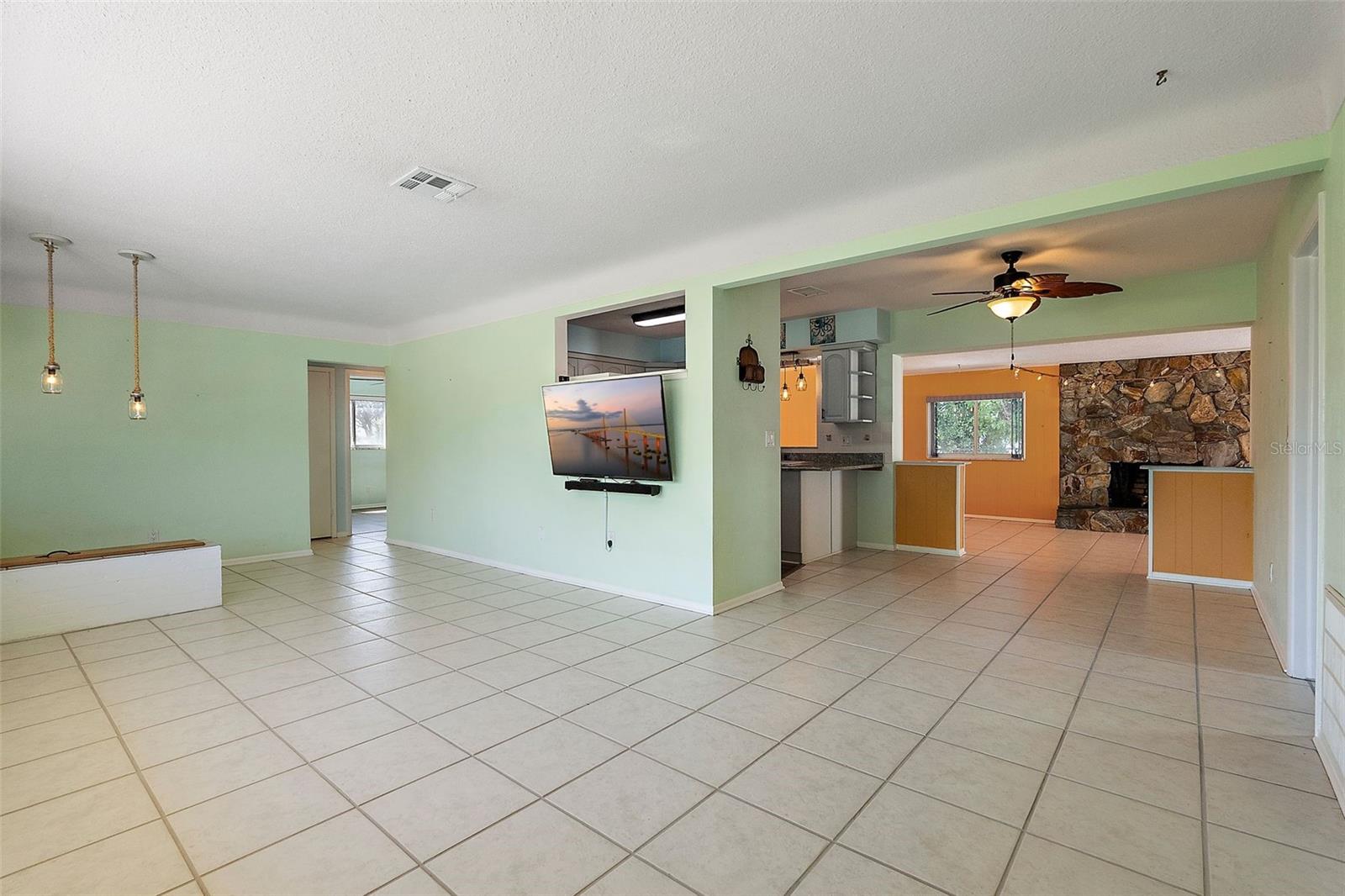 LIVING ROOM LOOKING INTO KITCHEN ON LEFT AND FAMILY ROOM WITH FIREPLACE