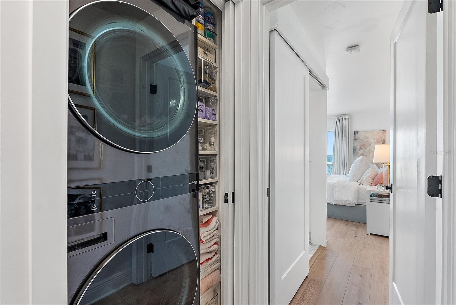 full size laundry with custom cabinets for storage