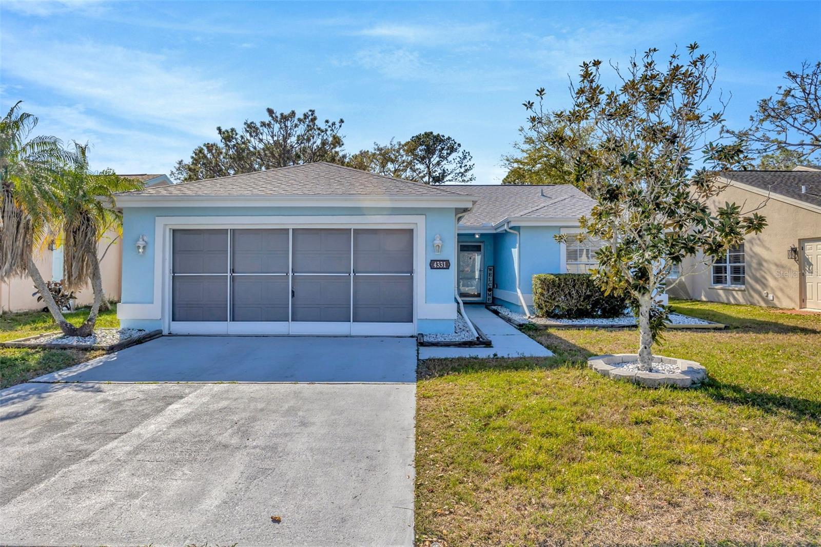 A two-car garage with a screened door provides practical convenience.