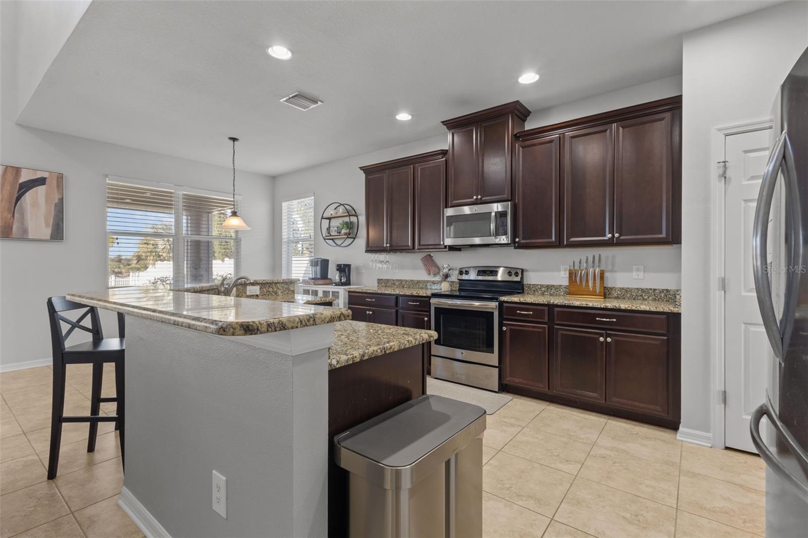 Granite, stainless steel and seating makes this kitchen modern and inviting