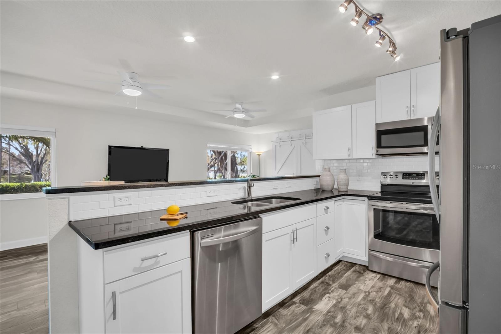 Open kitchen into main living, newer cabinetry, recessed lighting, & stainless appliances~