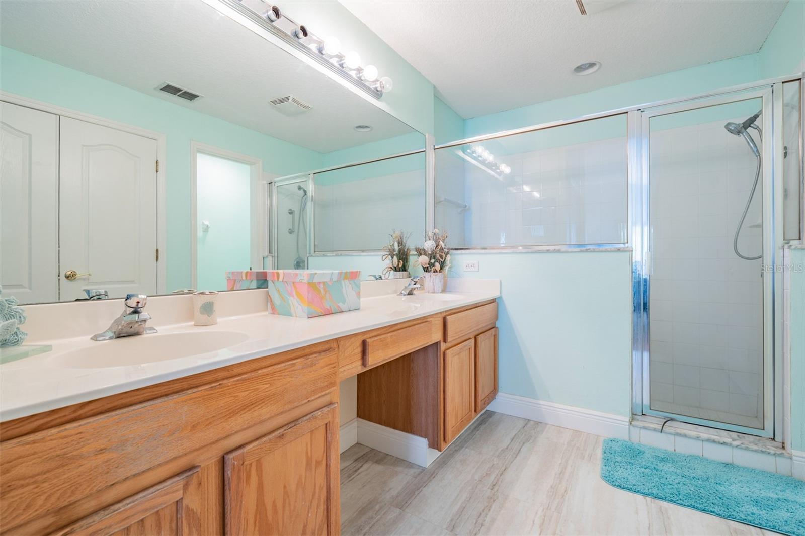 Dual sinks, vanity area, wood cabinets and new floors...large shower and water closet