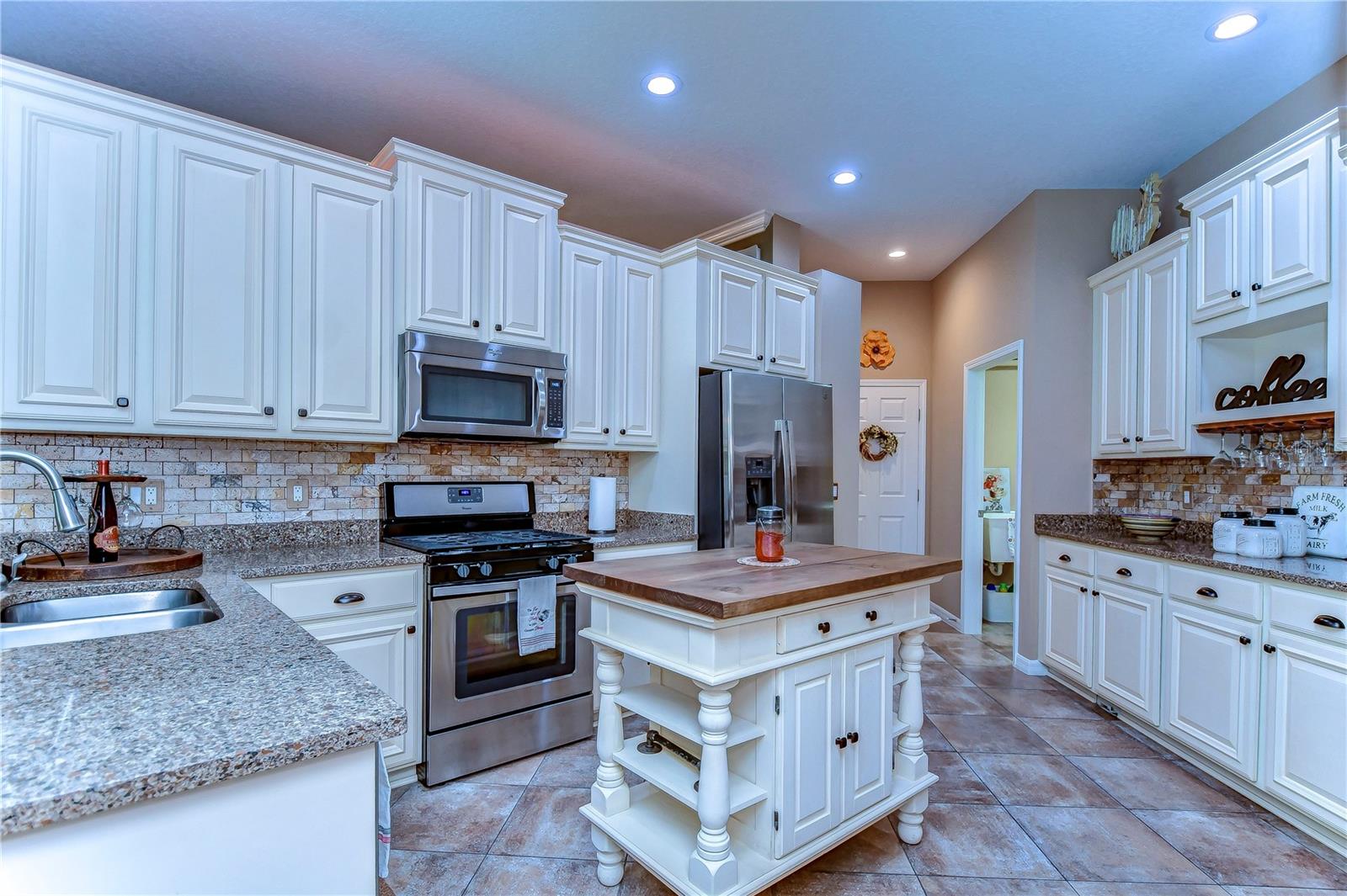 This inviting kitchen, features gleaming granite countertops, stainless steel appliances, and charming cabinetry.