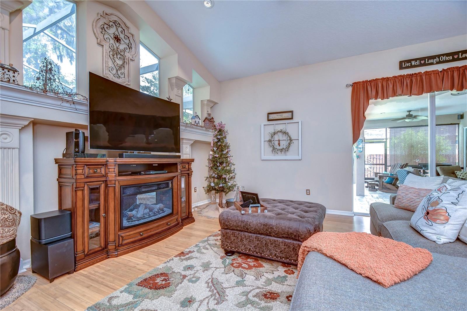 Elegant fireplace, ample natural light, and towering windows create an inviting atmosphere