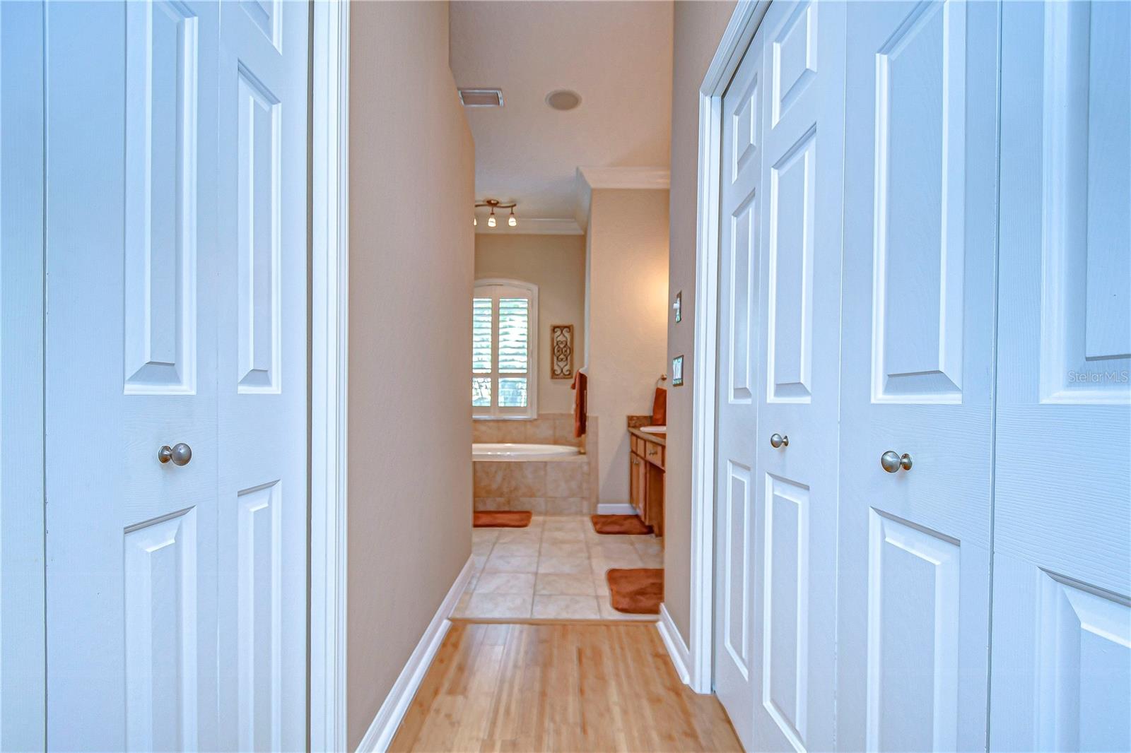 Elegant double closets open to a spacious bathroom with a soaking tub, perfect for unwinding after a long day.