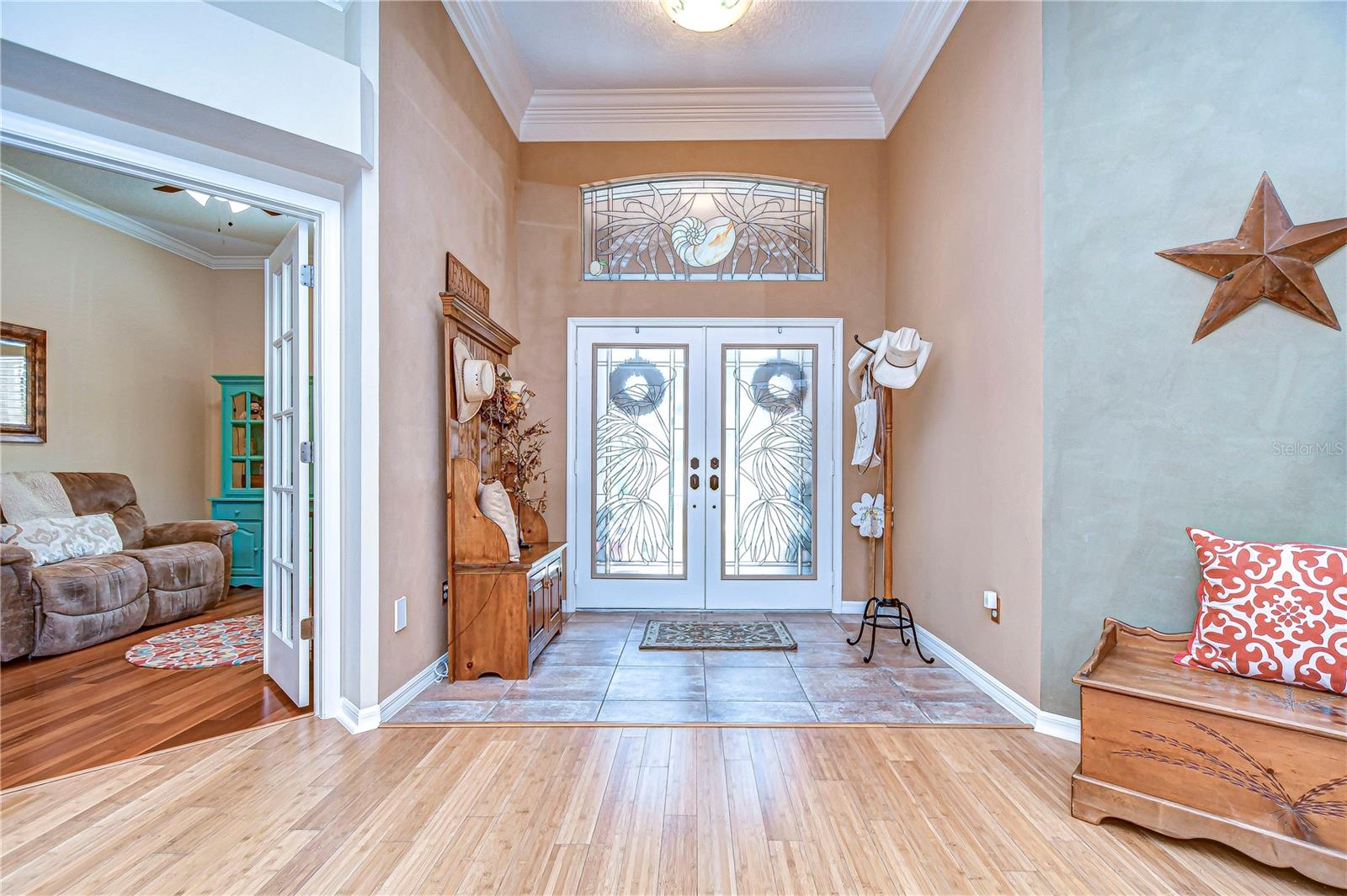 Step into a welcoming foyer featuring elegant double doors with intricate glasswork, setting the tone for a home filled with character and charm.