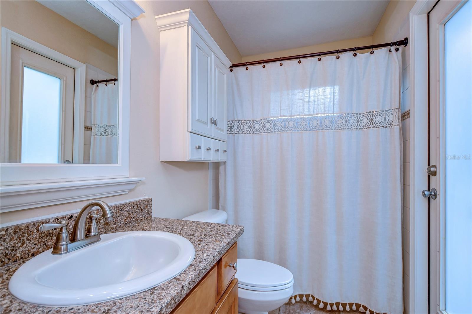 Step into serenity in this inviting bathroom featuring elegant granite countertops and great cabinetry.