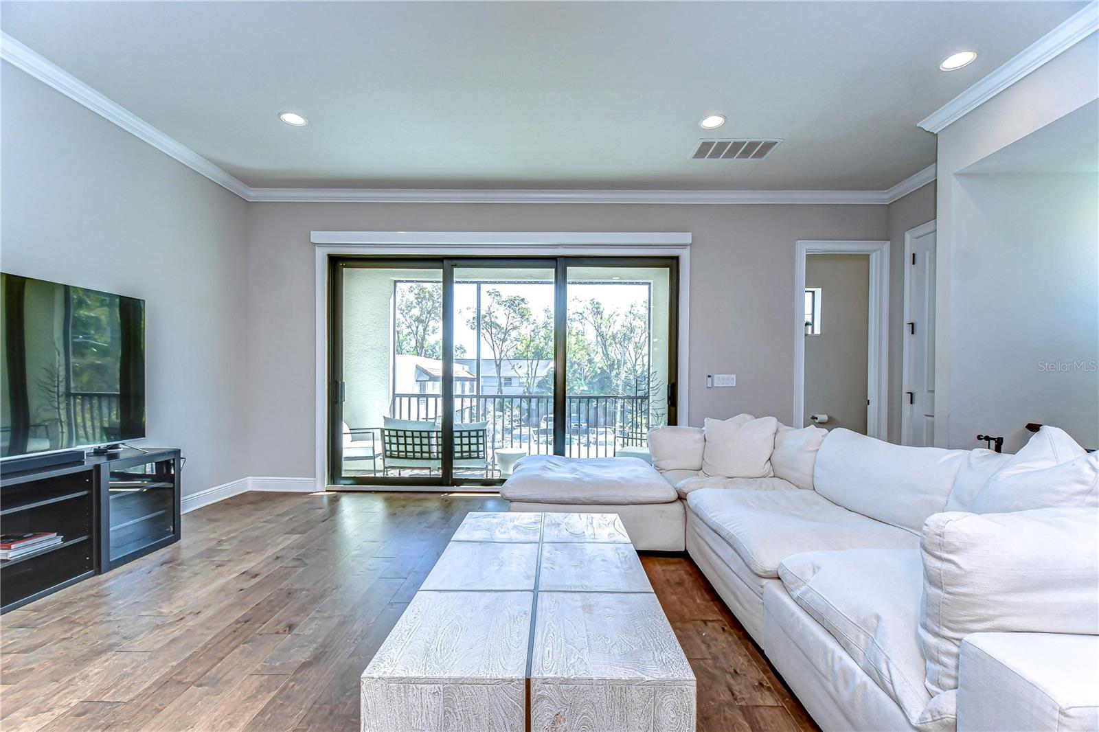 Relaxation and style converge in this elegant living space, featuring sleek sliding doors that open to a serene balcony vista.