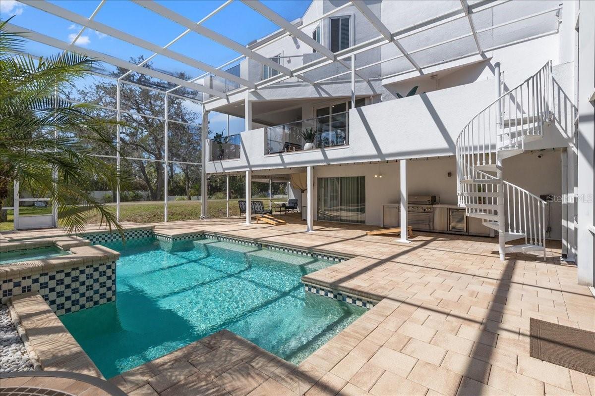 Ample covered area on the pool deck with outdoor kitchen