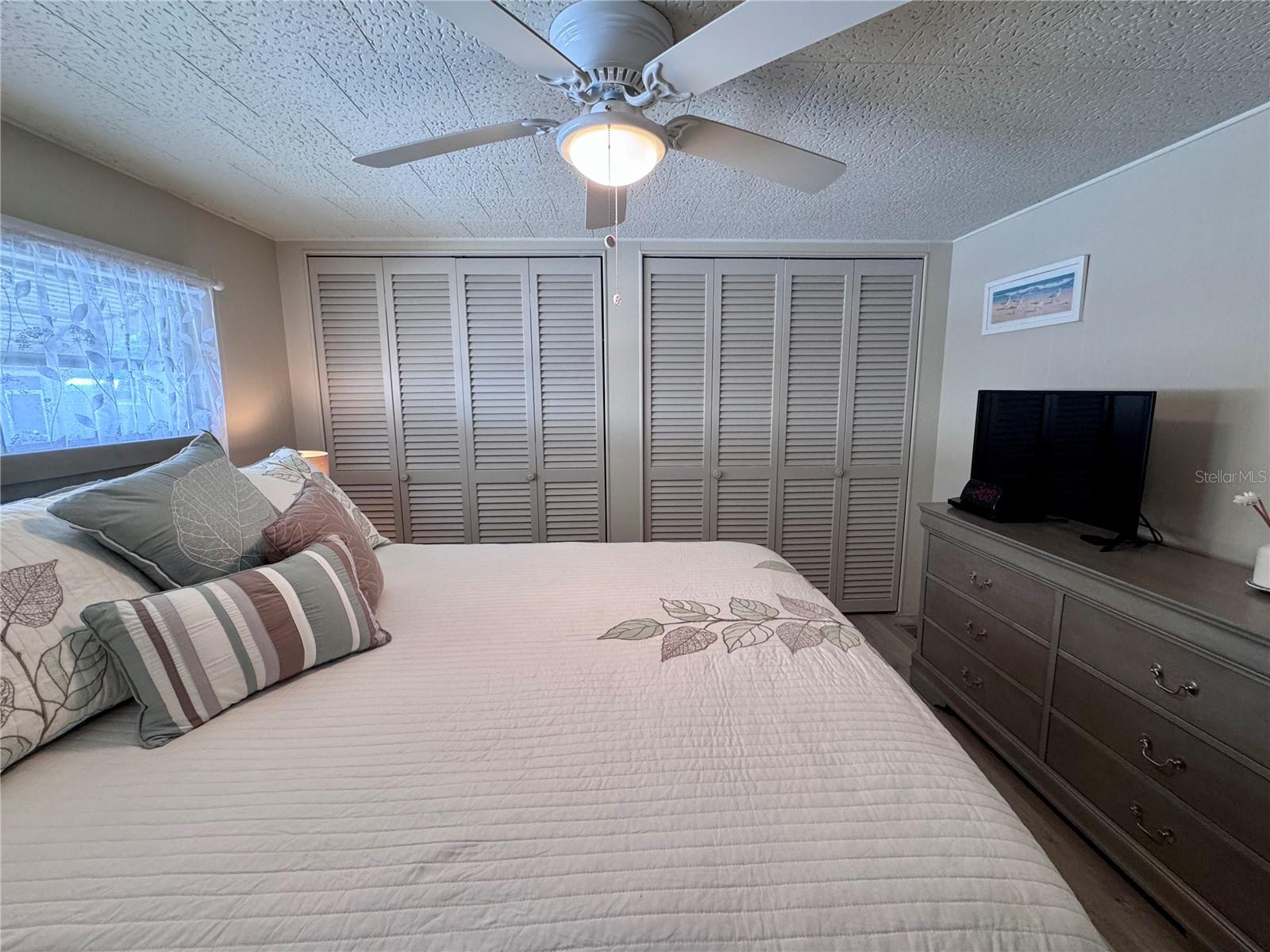 Primary bedroom with vinyl plank flooring.