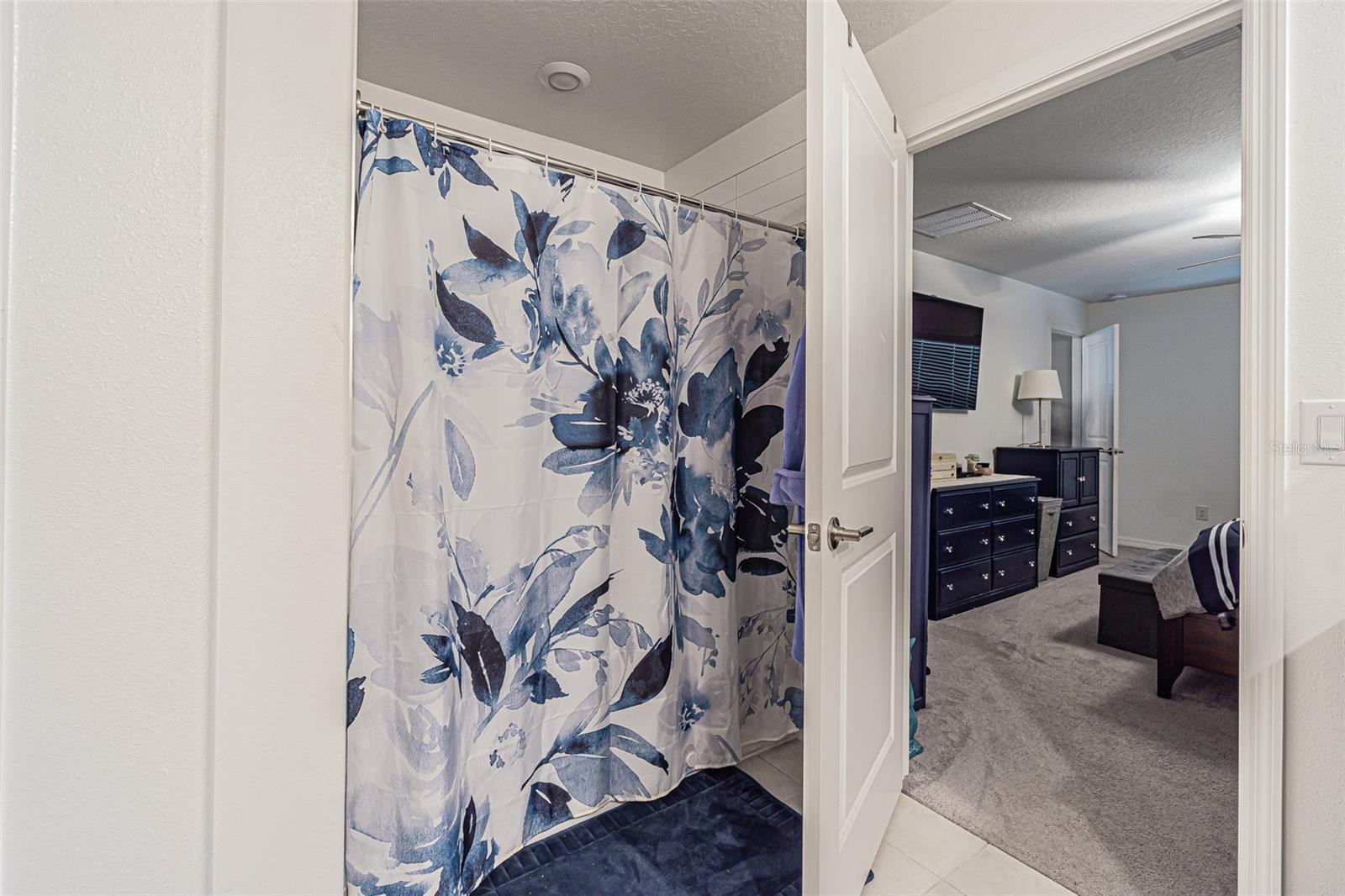 Double sinks, granite countertops, white shaker cabinets in primary bath