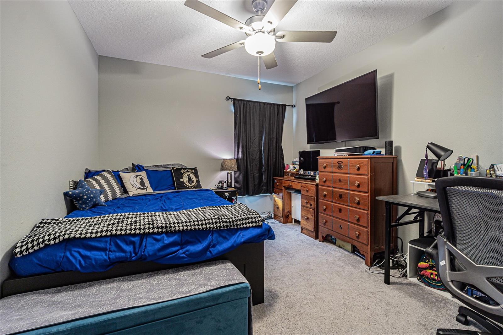 Bedroom 3 in the middle, being used as an office and includes custom shelves over the window and closet