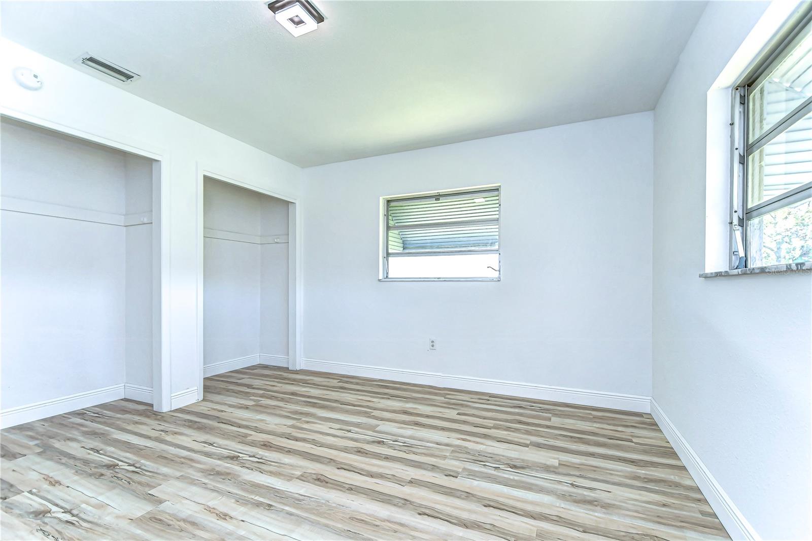 Bask in the natural light streaming through dual windows in this spacious bedroom, perfect for crafting your personal retreat.