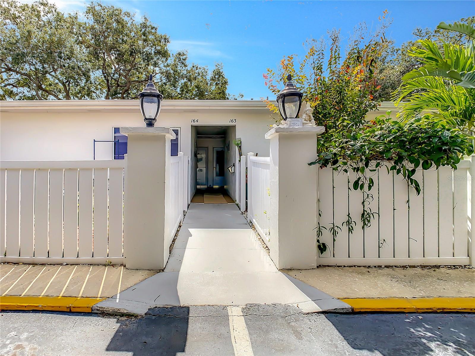 View towards front door from under carport ( assigned parking spot & guest spots)