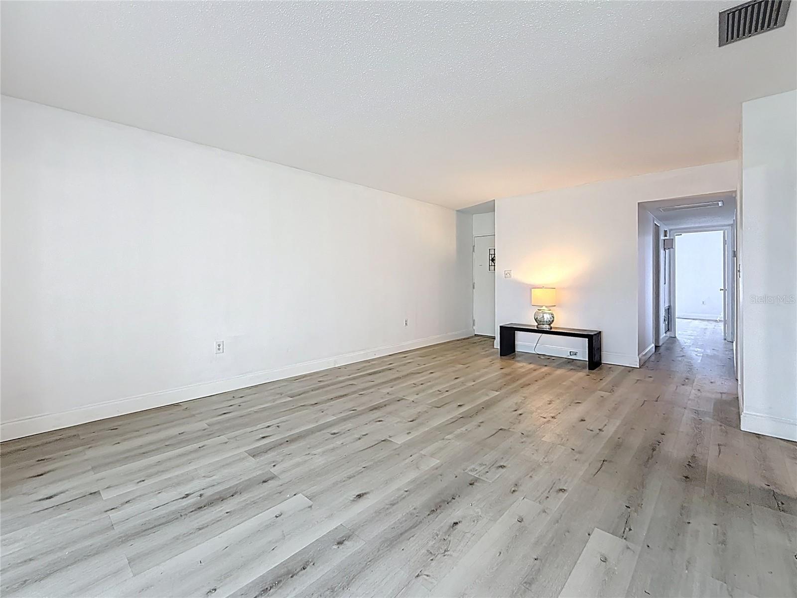 To your right is the dining area, view is looking towards the great room. The hall to the right leads to the hall guest bath and guest bedroom ( plus primary bedroom, but not visible in the view)