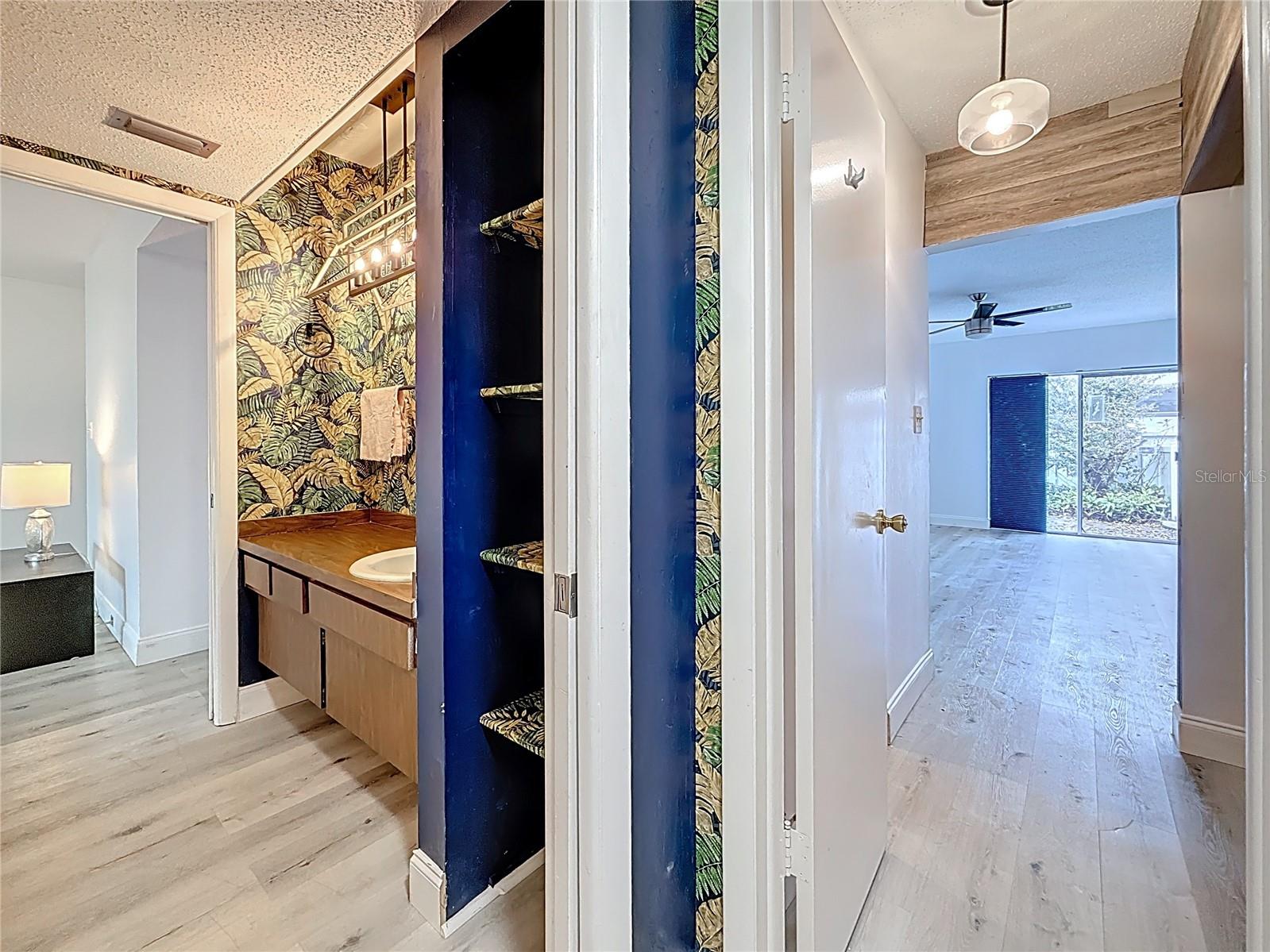 From private water closet in the primary bath towards the vanity area. Across from the vanity is the washer/dryer laundry closet. To the right & just past the door, is an alcove which can easily accommodate a large bureau or a rod can be added to create even more hanging space for clothing. Immediately behind the same door is a large walk-in closet, in next photo. The primary bedroom is right there, too.