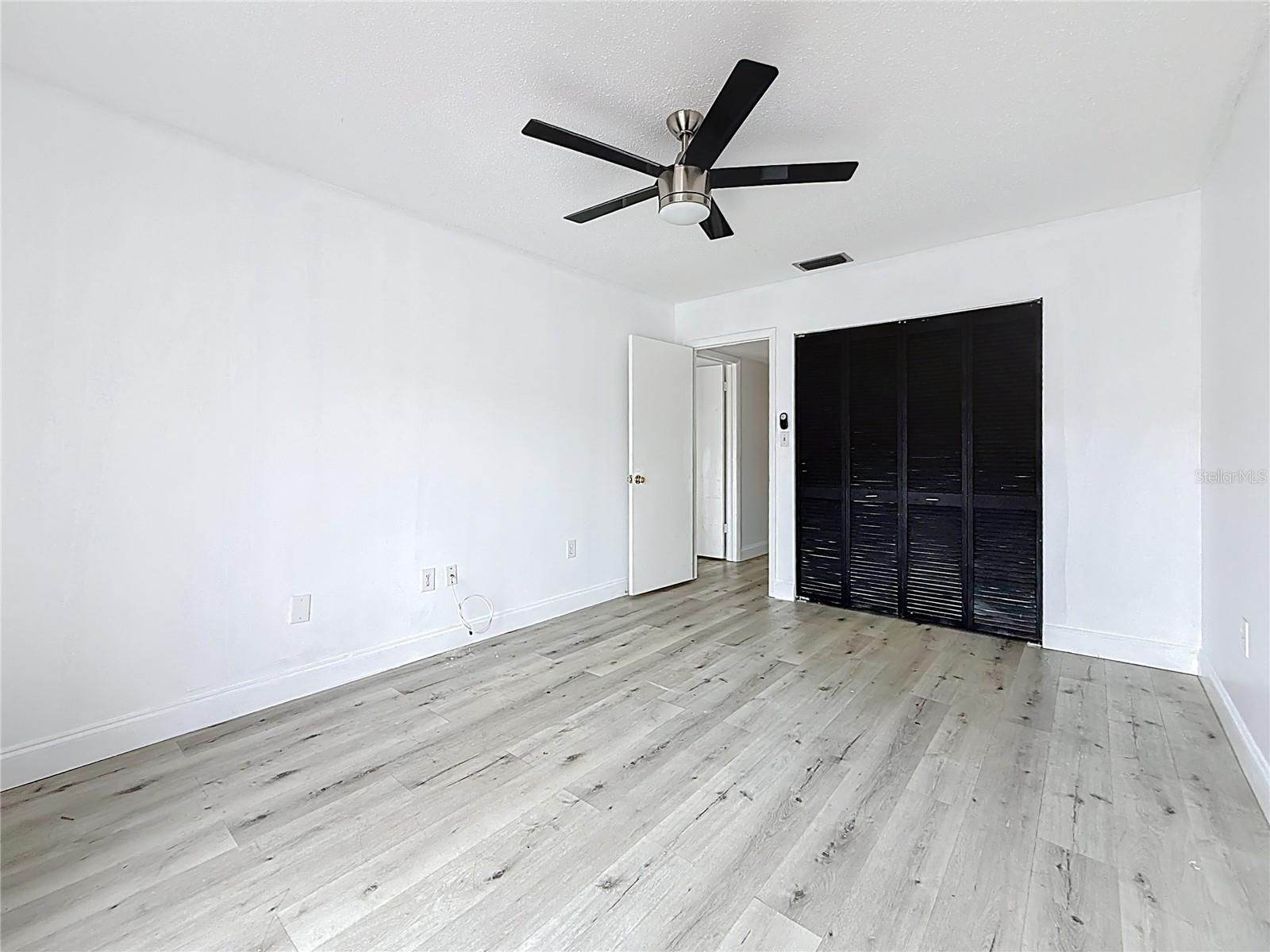 Your back is to the sliding glass doors, looking towards the guest bedroom entrance and wall closet (black doors)