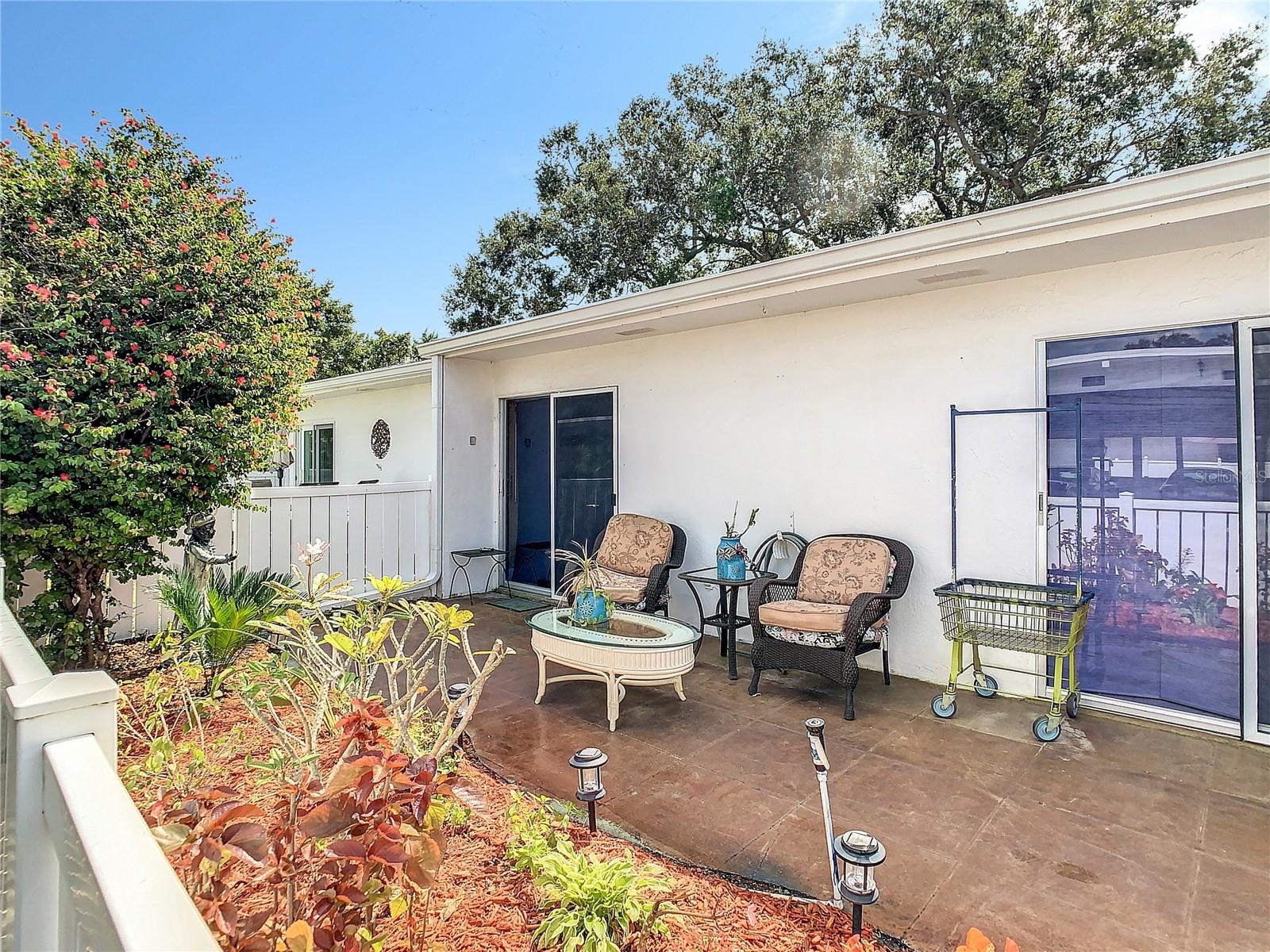 Front porch of villa. Sliding door to the left is primary bedroom, sliding door on the right is guest bedroom