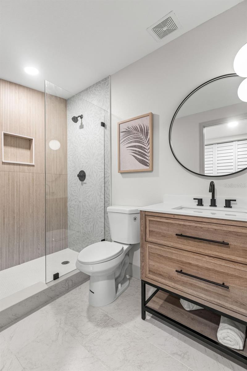 Primary bath with seamless glass shower and tastefultouches