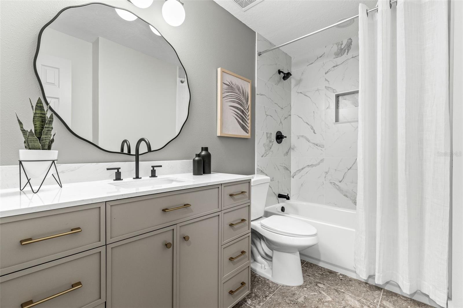 Guest bathroom with updatedvanity, tile flooring,shower/tub combo