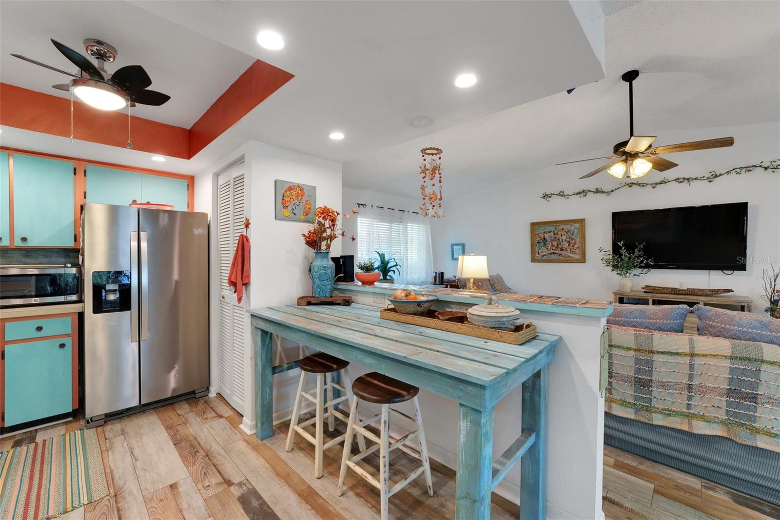 This picture showcases a beautiful view of the galley-style kitchen, featuring a one-of-a-kind, handmade bench that comfortably seats two in the cozy eat-in area—perfect for casual meals or enjoying a coffee in the morning.