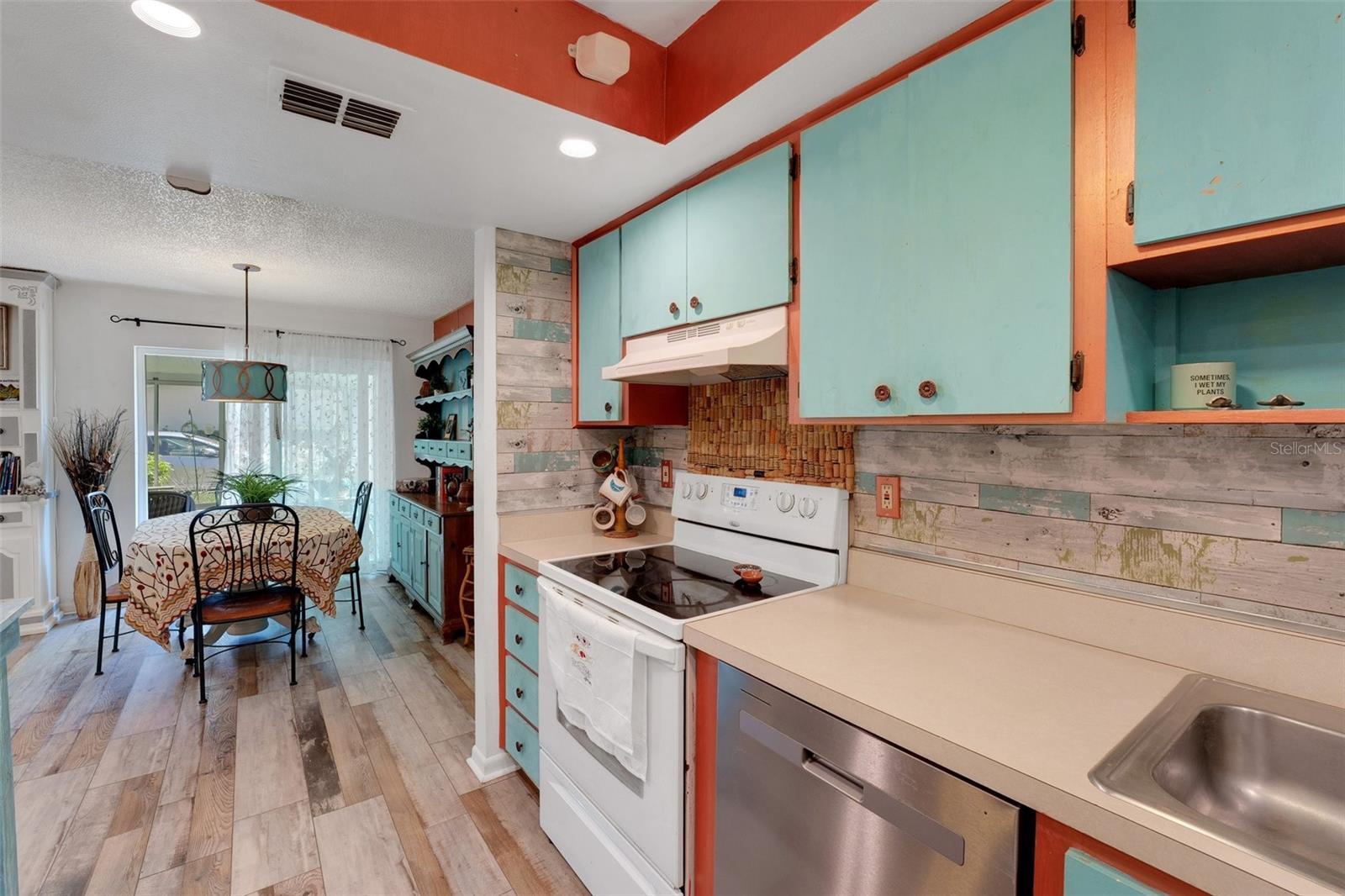 This view from the galley-style kitchen highlights the functional layout and seamless flow into a separate dining area at the end.