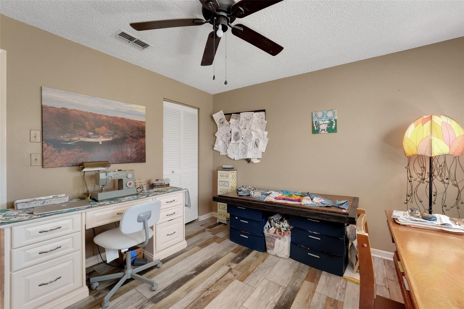 Second bedroom currently used as a sewing room, featuring a spacious desk and bulletin board—perfect for creativity and organization. ???? #ForSale"