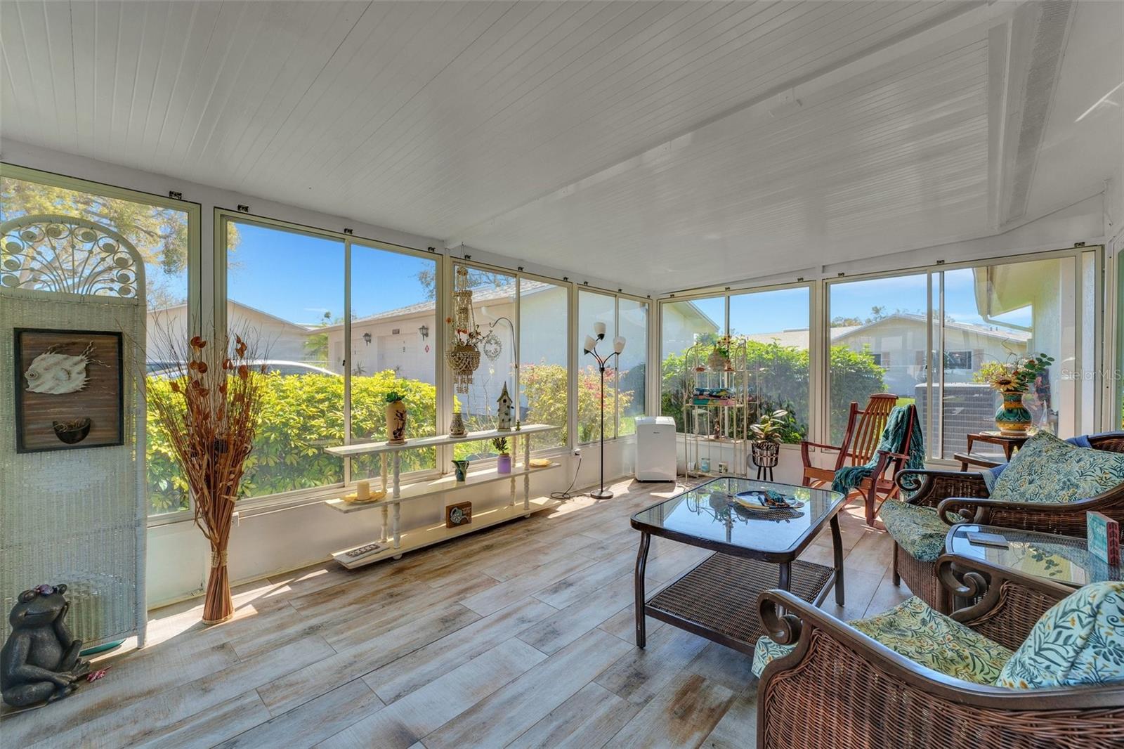 Bask in the sunshine: This bright and airy enclosed porch, complete with newer sliders, offers two entry points into the heart of the home.