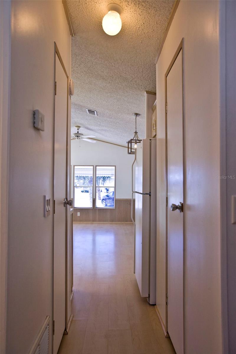 Hallway from kitchen with storage closets