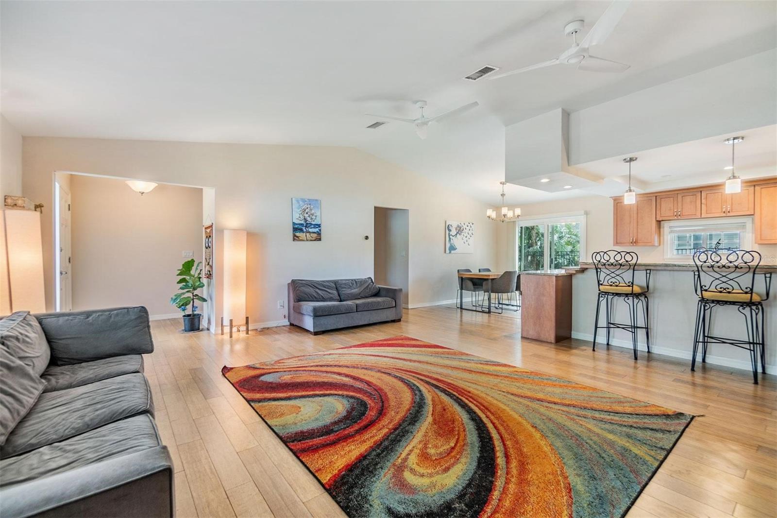 Open concept living space accentuated by vaulted ceilings. An inviting living room with wood-burning fireplace breakfast bar joining the living room with the kitchen and eating, dining area just off the kitchen.