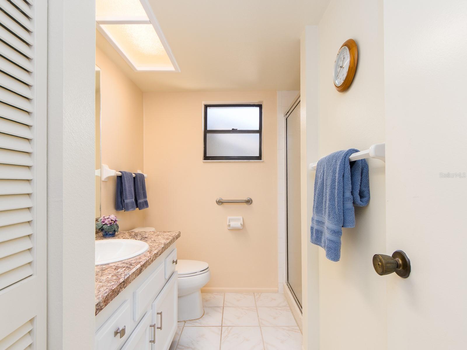 SECOND BATH WITH WHITE SHAKER CABINETRY AND A WALK IN SHOWER