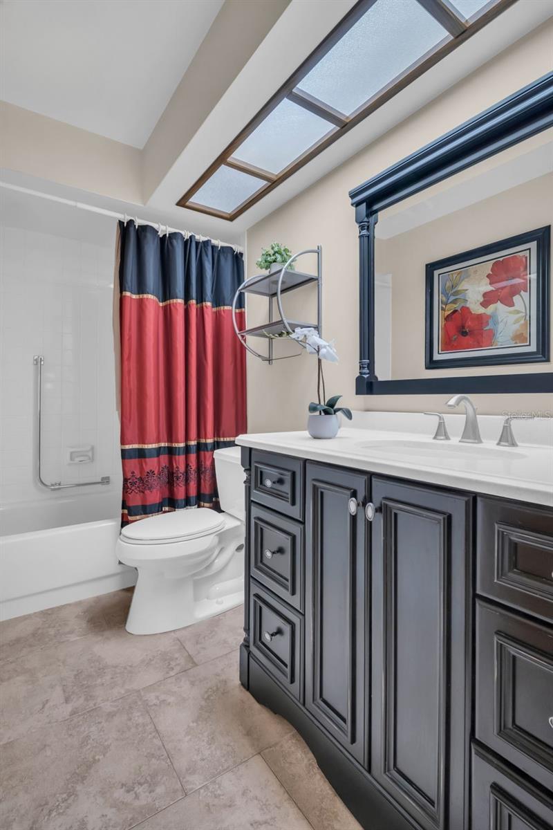 Hall bath perfectly positioned between the main living & guest suite with tub/shower combo & updated vanity~