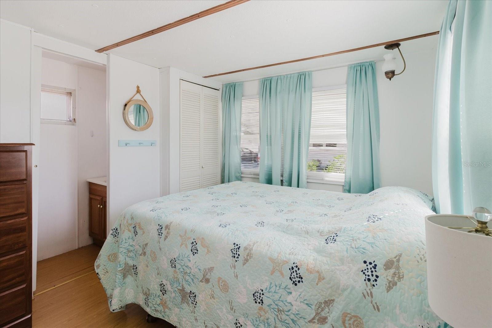 Secondary Guest Bedroom With Half Bath, Built In Closet, and Laminate Floors Throughout