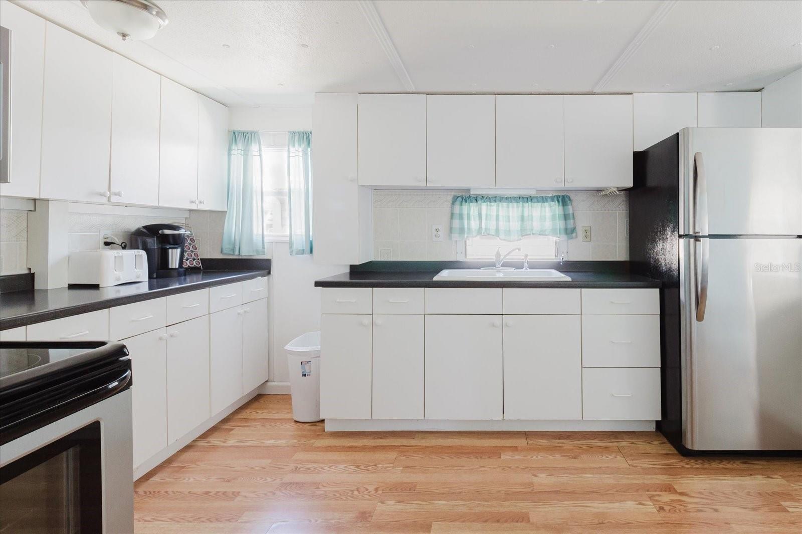 Open Concept Kitchen With Stainless Steel  Appliances and Eat In Kitchen