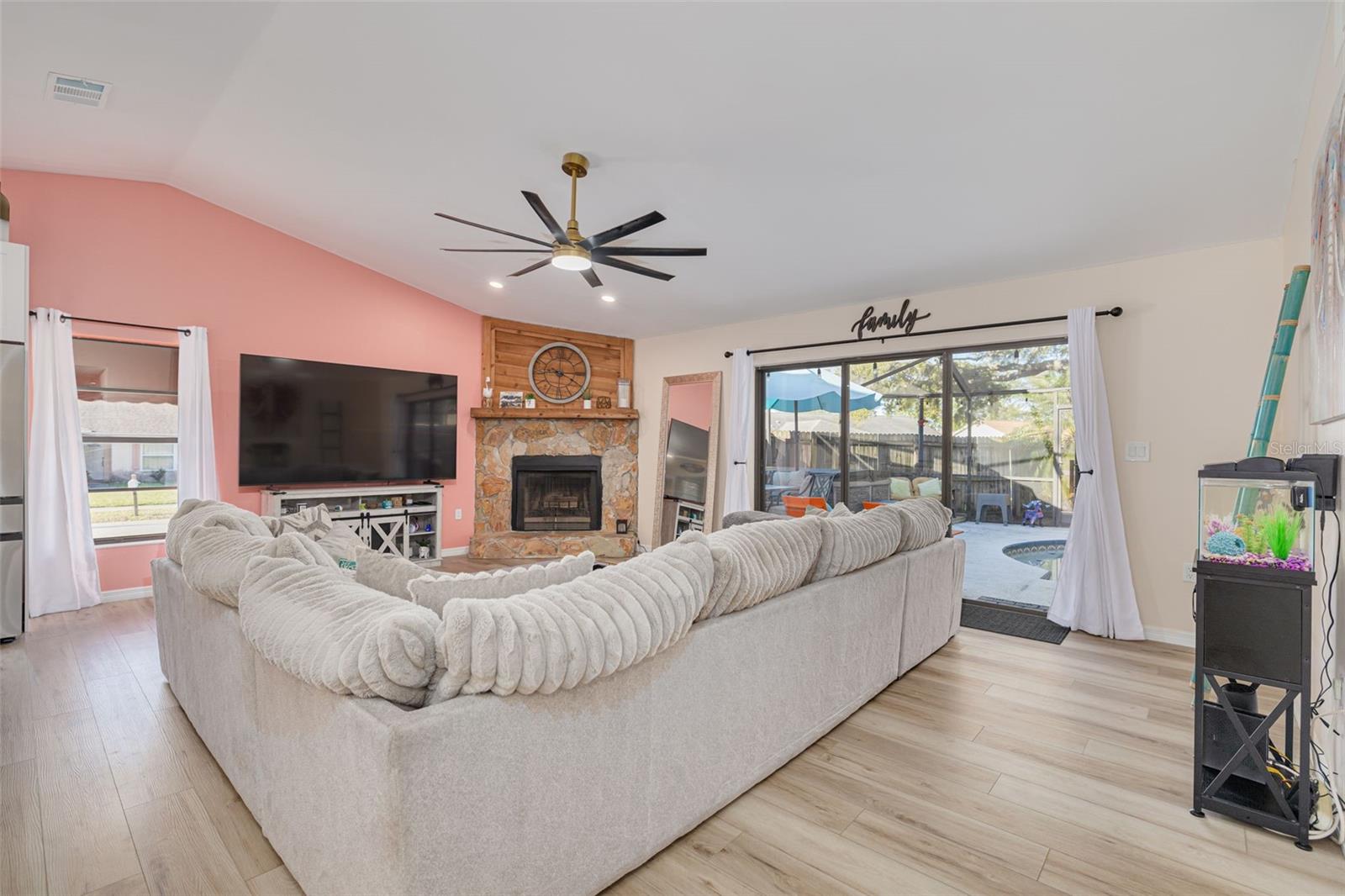 Living room with fireplace and access out to the pool