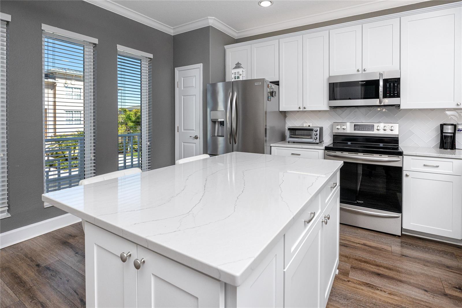 Gorgeous Cambria Countertops, oversized island and herringbone backsplash